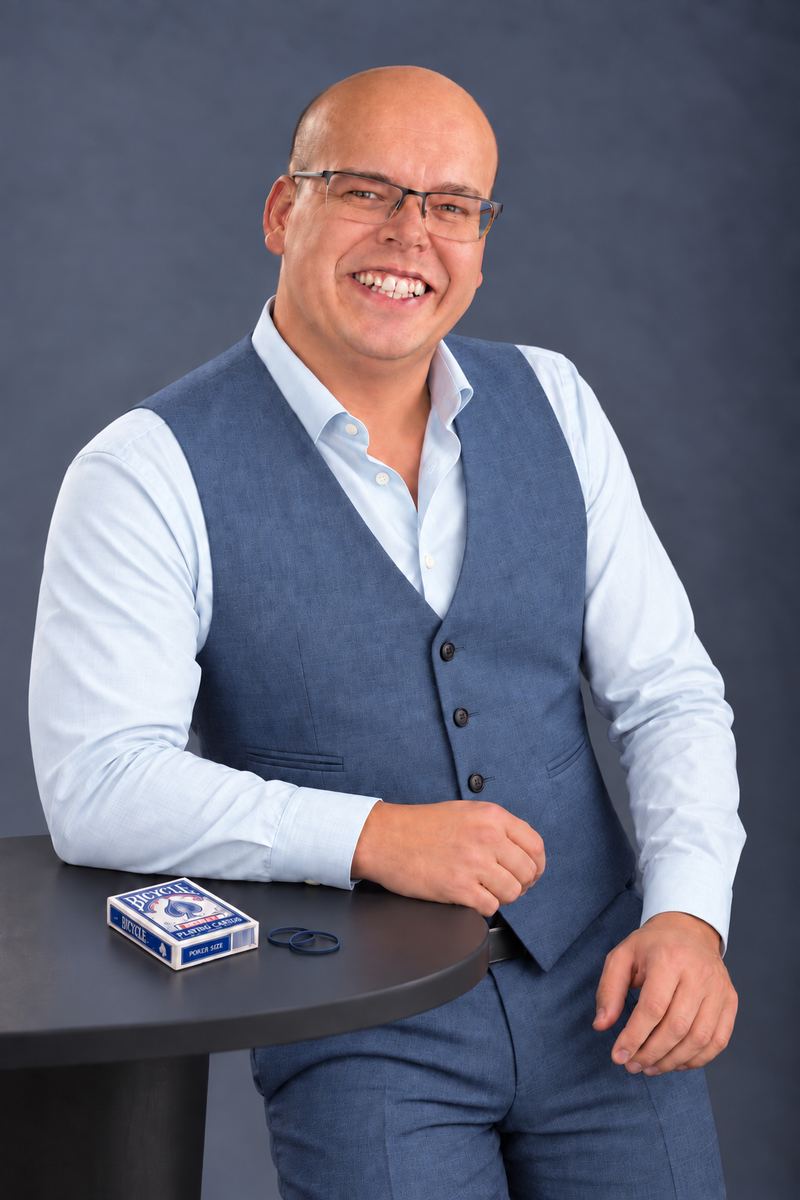 Jesse Ray aan een statafel met een spel kaarten